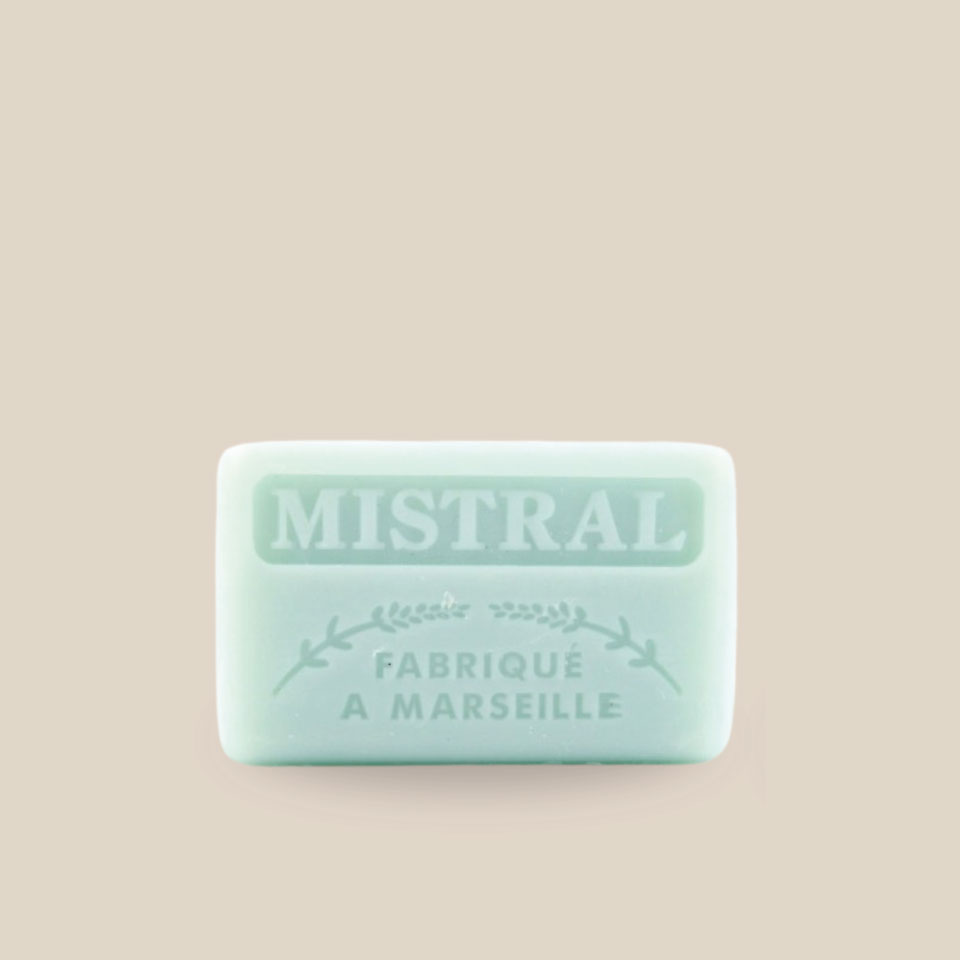Photo produit prise de face : Savonnette marseillaise au beurre de karité, de couleur bleu très pâle, inspirant calme. Parfumée au Mistral, fabriqué à Marseille. 125g.