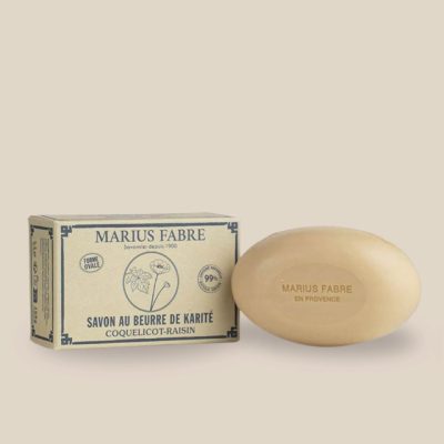 Product photo: Oval beige soap with shea butter and sweet almond oil, poppy-grape scented, comes in a recycled box.